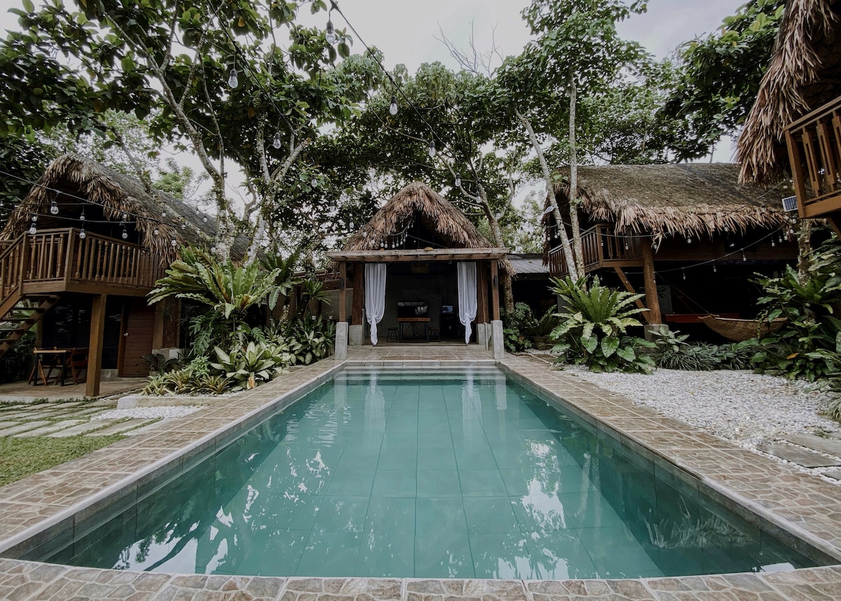 Beladi Villas Amadeo exterior with pool, thatched-roof buildings, and tropical garden